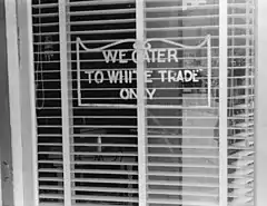 A sign reading "We Cater to White Trade Only.