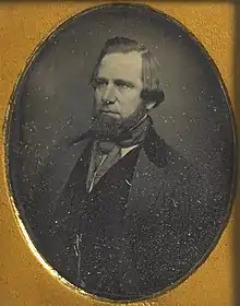 Photograph of a man facing left, with chin beard and longish hair