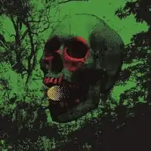 A mostly green-and-black monochromatic image of a skull, with red teeth and red coloration around its eye sockets and with a small orange-and-black sphere held in its teeth, in front of a forest and a flat green background.