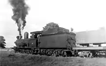 A black and white photo of a steam train blowing steam