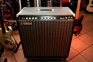 A wooden speaker cabinet with an integrated amplifier.