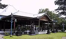 Brown wood pavilion with statues