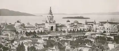 View north-northeast; the Tower of Jewels is prominent in the center, and the domed Palace of Horticulture can be seen on the left. Alcatraz Island can be seen in the background.