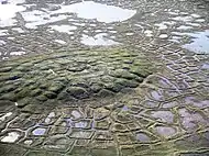 Example of a pingo on Earth.  On Earth the ice that caused the pingo would melt and fill the fractures  with water; on Mars the ice would turn into a gas in the thin Martian atmosphere.