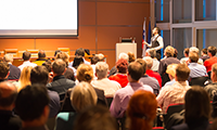 photo of a conference speaker giving a presentation