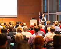 photo of a convention speaker presenting slides