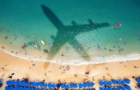 Shadow of airplane flying over beach