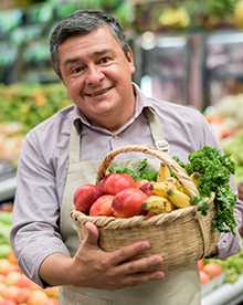 Grocery store owner with basket of vegatables
