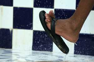 Foot with flip-flop in shower.