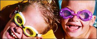 Two kids with goggles swimming