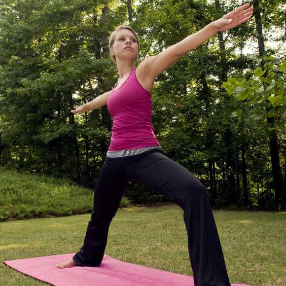 young woman getting in some exercise time by practicing Yoga poses.