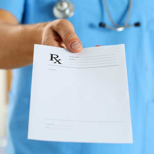 Healthcare provider holding out a blank prescription pad