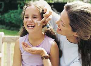 Mother Applying Suntan Lotion to her Daughter