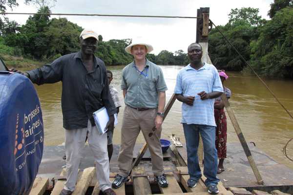 A CDC responder and colleagues standing on a raft on a river