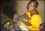 A woman in Kenya cooking over an open fire