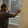 Man installs indoor window screens