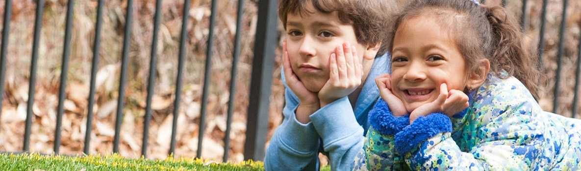 Muchacho y muchacha que ponen en la hierba