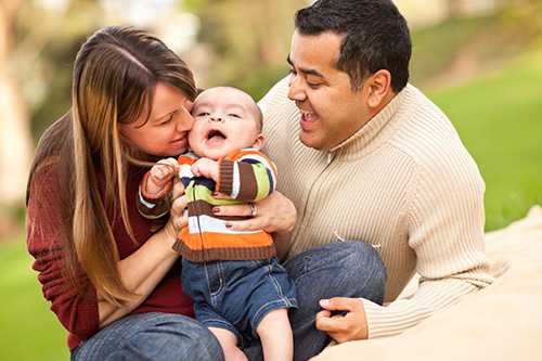 Family with and infant sitting outside