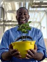 Man Holding a hard hat with plant inside
