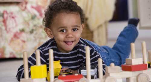 Boy lying on the floor playing with blocks