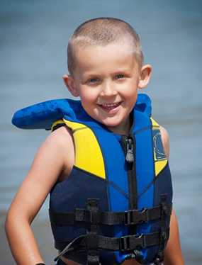 photo: girl wearing a life jacket on the beach