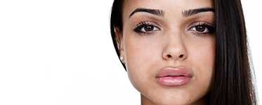 A young woman looking straight ahead, showing strength.